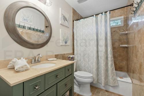 a bathroom with a sink and a toilet and a mirror at 4937 Windward Place home in Fernandina Beach