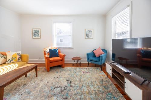 a living room with two chairs and a tv at Modern Mill House Walk to Downtown Durham in Durham