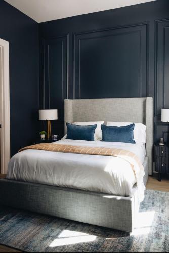 a bedroom with a large bed with blue walls at The Purple Martin - Nest in Louisville