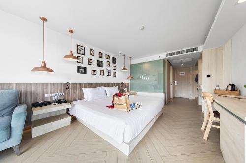 a hotel room with a bed with a bag on it at Mayaana Beach Resort Pattaya - Formerly Golden Tulip Pattaya Beach Resort in North Pattaya
