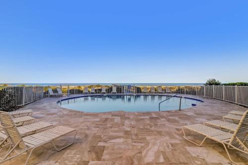 a large swimming pool with two chairs on a patio at Ocean Place Condo in Amelia Island