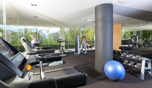 a gym with treadmills and machines in a room at Botanica Khao Yai by Scenical in Mu Si