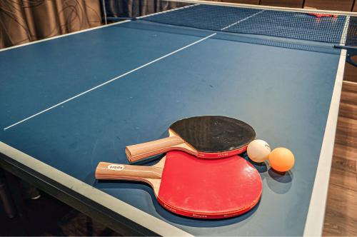 a ping pong paddle and balls on top of a pool table at 最大19人一棟貸切4Bed rooms福島 in Osaka