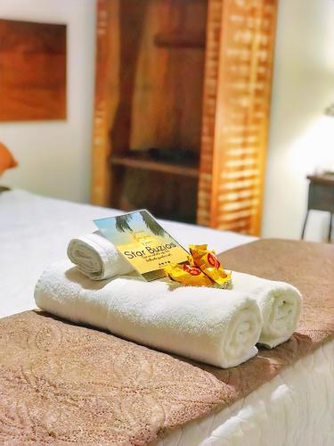 a pile of towels sitting on top of a bed at Star Búzios Pousada in Búzios