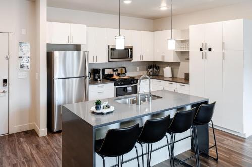 ソルトレイクシティにあるConvention Ctr Style-2BR Pool,Hot Tub,Gym,Theatreのキッチン(黒い椅子付きの大きな島付)