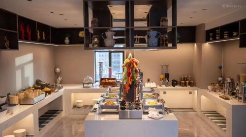 a room with a counter with a lot of food at UrCove by HYATT Aksu in Aksu