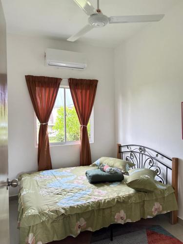 a bedroom with a bed and a window with curtains at Kampung Boi Homestay in Melaka