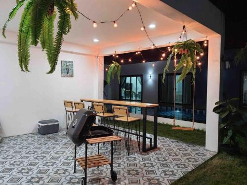 - une table et des chaises sur une terrasse éclairée dans l'établissement Morning Glory Pool Villa Chaam-Huahin, à Sathani Huai Sai Tai