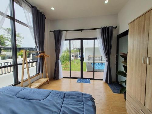 - une chambre avec un lit et un balcon avec une piscine dans l'établissement Morning Glory Pool Villa Chaam-Huahin, à Sathani Huai Sai Tai