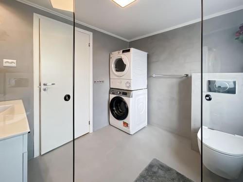 une salle de bains avec lave-linge et toilettes dans l'établissement Cozy Corner 1 By Stavanger Bnb, à Stavanger