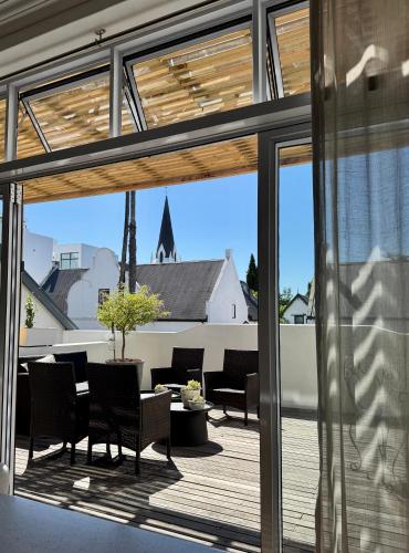 a patio with a table and chairs and windows at Tuishuisie in Stellenbosch
