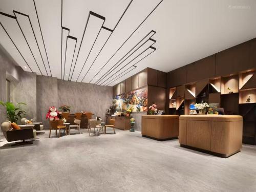 a lobby with a waiting area with tables and chairs at UrCove by HYATT Aksu in Aksu