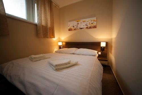 a bedroom with a white bed with towels on it at Penzion Set in Košice