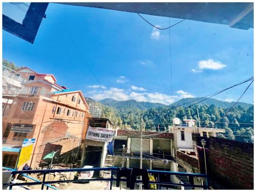 a view of a city with mountains in the background at DALHOUSIE HOTEL S A H A R A - Near Bus Stand - Hygiene & Spacious Room in Banikhet