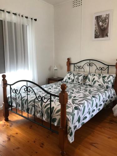 a bedroom with a bed with a black and white comforter at Swanpool - Serendipity House in Swanpool