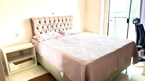 a bedroom with a bed with a pink blanket and a window at Umarizal in Belém