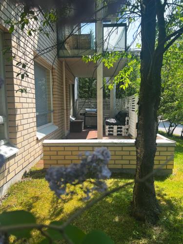 a front porch of a house with a tree at Lovely 1-bedroom apartment with patio and sauna in Tampere
