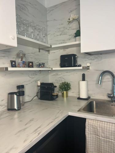 a kitchen with white marble counter tops and a sink at Lovely 1-bedroom apartment with patio and sauna in Tampere