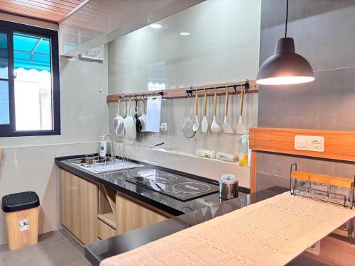 eine Küche mit Herd und Arbeitsplatte in der Unterkunft hillcure villa kota bunga puncak by citrus house in Cikundul