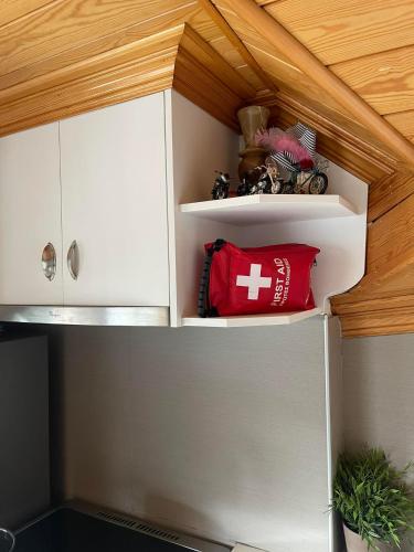a small kitchen with white cabinets and a red pillow at Kostis Central Loft in Metsovo