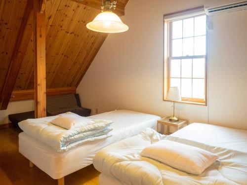 a bedroom with two beds and a window at Elle's Garden House in Nasushiobara
