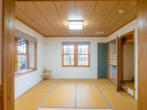 an empty room with a wooden ceiling at Elle's Garden House in Nasushiobara