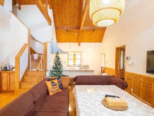a living room with a couch and a christmas tree at Elle's Garden House in Nasushiobara