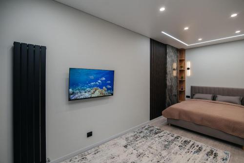 a bedroom with a bed and a television on the wall at ЖК Sun city in Oral