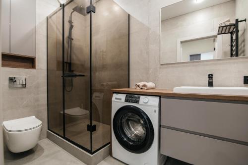 a bathroom with a washing machine and a sink at ЖК Sun city in Oral