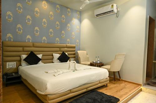 a bedroom with a large white bed in a room at Dnyanprabha Executive in Tuljapur