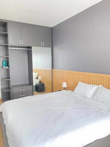 ein Schlafzimmer mit einem großen weißen Bett und grauen Schränken in der Unterkunft Căn hộ biên hoà in Biên Hòa