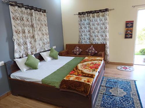 Un dormitorio con una cama grande con almohadas verdes. en Yuvraj Nature Resort, en Pushkar