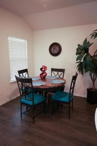 a dining room with a table and four chairs at Spacious 4-Bedroom Retreat with High-Speed WiFi and Tranquil Ambiance in Aubrey