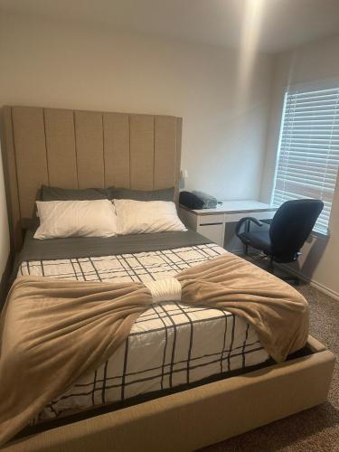 a bedroom with a bed and a desk and a chair at Spacious 4-Bedroom Retreat with High-Speed WiFi and Tranquil Ambiance in Aubrey
