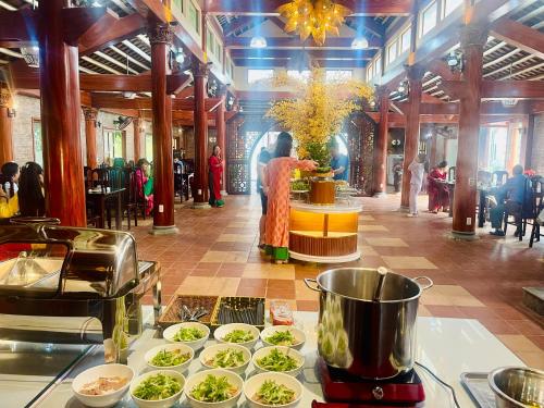a woman standing in a room with plates of food at Hoa Lu Garden Resort in Ninh Binh