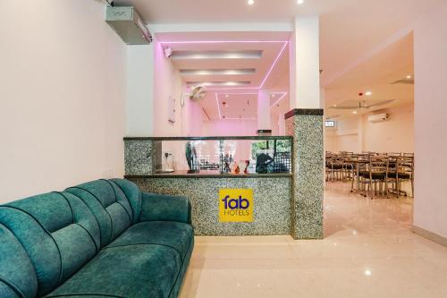 a living room with a couch and a restaurant at FabHotel Relax Inn I in Kānpur