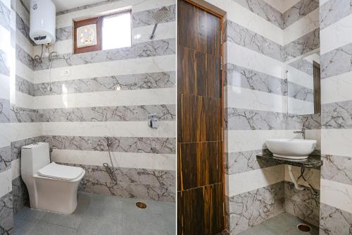 a bathroom with a toilet and a sink at FabHotel Relax Inn I in Kānpur