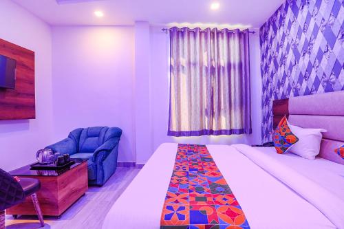 a hotel room with a bed and a chair at FabHotel Relax Inn I in Kānpur