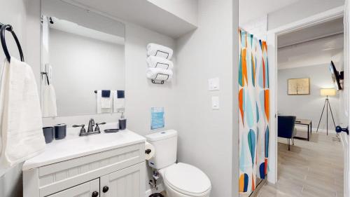 a white bathroom with a toilet and a sink at Gorgeous 2-King-Bed Lower Unit in Denver in Denver
