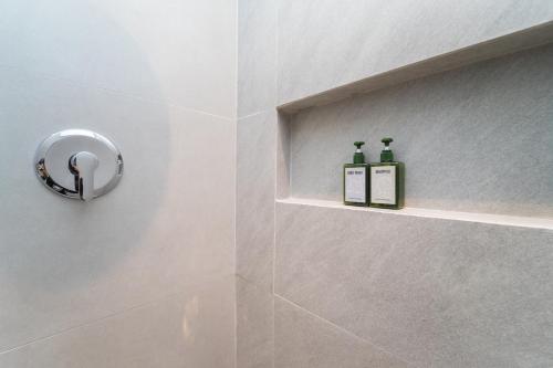 a bathroom with a shower with two bottles on the wall at Keenan Living Luxe Seturan in Seturan