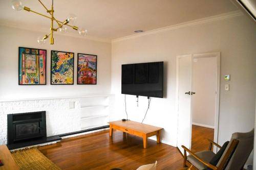a living room with a table and a fireplace at Oxford Retreat in Martinborough 