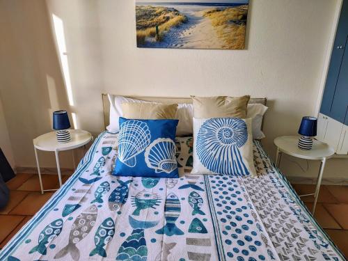 a bed with blue and white pillows on it at Enjoy The Sea in Calasetta