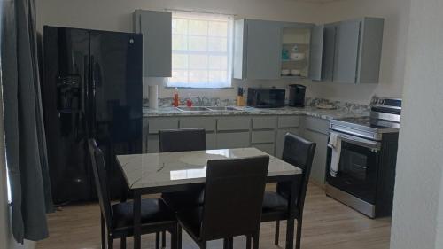 a kitchen with a table and chairs and a black refrigerator at House in Malvern, AR in Malvern