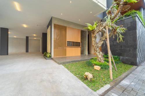 a courtyard with a tree in front of a building at Keenan Living Luxe Seturan in Seturan