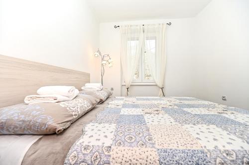 een slaapkamer met een bed met een dekbed erop bij Apartment Aldora in Zadar