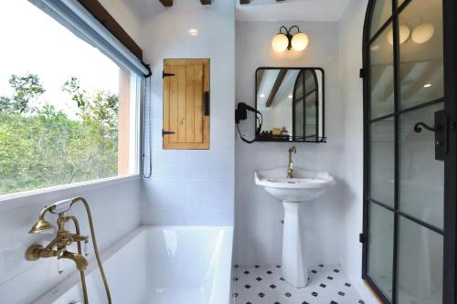 a bathroom with a tub and a sink at Moon River Village in Ban Bu Khanun