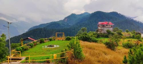 a house on a hill with mountains in the background at Orchard Green Dummi in Nāldera