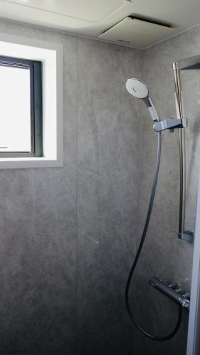 a shower with a shower head in a bathroom at 新築オーシャンビュー離れ FLAG Awaji HANARE in Awaji