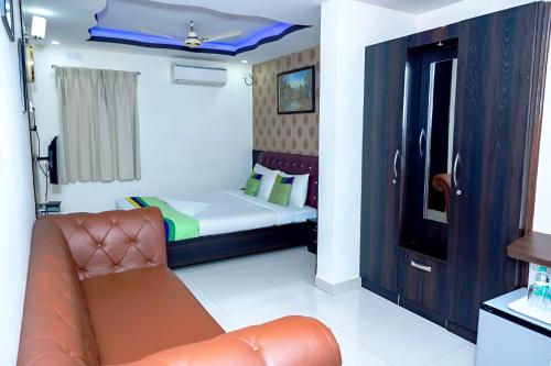 a small bedroom with a bed and a couch at Palani Andavar in Bangalore