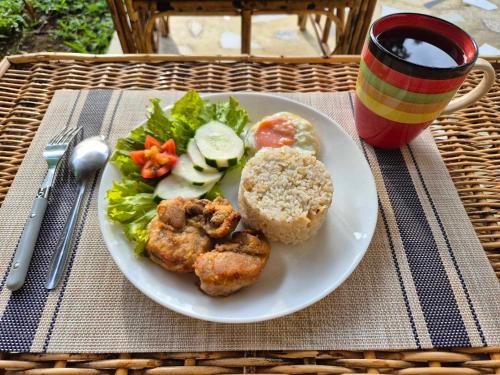 a white plate with a sandwich and salad and a drink at Amazing Ocean View Treehouse & Pool in Puerto Princesa City